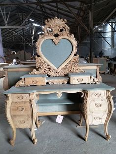 an ornate wooden desk with a heart shaped mirror on top