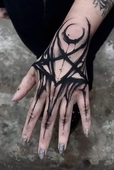 a person's hand with black ink on it and some rings around the wrist