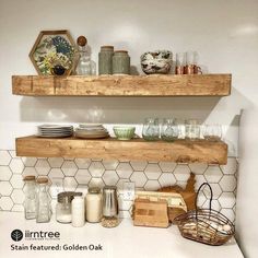 two wooden shelves filled with dishes on top of a white counter next to a tiled backsplash