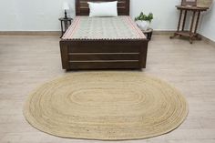 a bed sitting on top of a hard wood floor next to a white pillow and chair