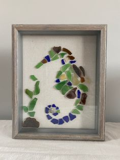 a frame that has some kind of glass in it with rocks and pebbles on it