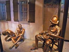 two bronze statues sitting next to each other