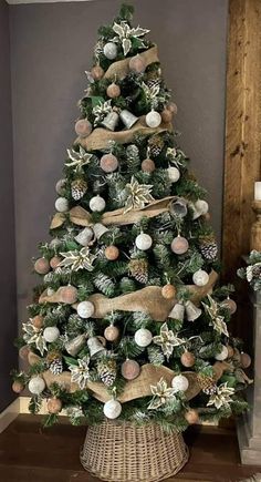 a decorated christmas tree in a wicker basket with burlocks and pine cones