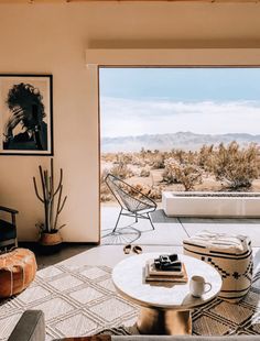 a living room filled with furniture and a large open door leading to a desert view