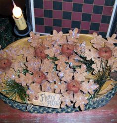 a bowl filled with cookies on top of a wooden table next to a lit candle