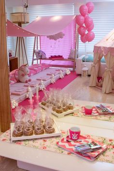 a table topped with lots of desserts and pink balloons