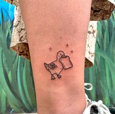 a small tattoo on the ankle of a woman's leg, depicting a bird holding a flower