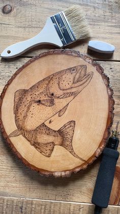 a wooden plate with a fish on it sitting next to a brush and razor blade