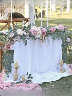 an outdoor ceremony setting with flowers and candles