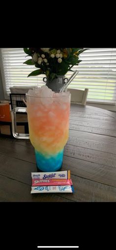 a tall glass filled with liquid sitting on top of a table next to three books