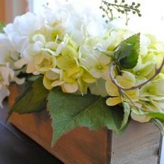 white and green flowers in a wooden box