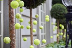 many tennis balls are flying in the air near a lamp post and street light pole