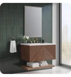 a bathroom with green tiled walls and a wooden sink vanity next to a large window