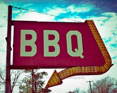 a red sign that says bbq with an arrow pointing to the right in front of it