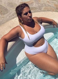 a woman in a white swimsuit leaning on the edge of a pool