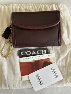 COACH MULTIFUNCTION WALLET MAHOGANY BROWN LEATHER HIDDEN SNAP CLOSURE - INSIDE BLACK SMOOTH LEATHER LINING  ZIP COIN POUCH SLIP POCKET UNDER FLAP BRASS HARDWARE KEYRING CARABINER CLIP COACH MINI HANGTAG  MADE IN COSTA RICA 1990'S  4 1/4"W X 3.5"H CONDITION - NEW OLD STOCK, COMES WITH SALES TAG, DUST BAG, THERE ARE A FEW LITTLE LIKE BLUE MARKS ON THE BACK RIGHT SIDE - PLZ SEE LAST PHOTO. NOT SURE WHAT THEY ARE, ALSO A FEW INDENTIONS - SEE ALL PHOTOS FOR FLAWS, THEY ARE VISIBLE THANK YOU Card Holder Wallet Keychain, Id Wallet Keychain, Wallet Inspo Aesthetic, Sunglasses Case Aesthetic, Classic Coach Coin Purse With Coin Pocket, Classic Compact Coach Coin Purse, Classic Coach Coin Purse, Classic Coach Leather Coin Purse, Brown Coach Wallet With Interior Key Chain Holder