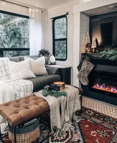 a living room filled with furniture and a fire place in front of a window on top of a rug