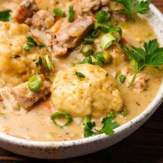 a white bowl filled with meat and vegetable soup