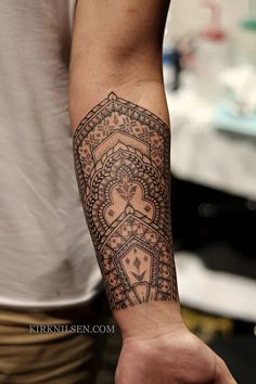 a man's arm with a tattoo on it that has an intricate design in the middle