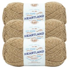 three skeins of lion brand heartland yarn in natural colors, on a white background