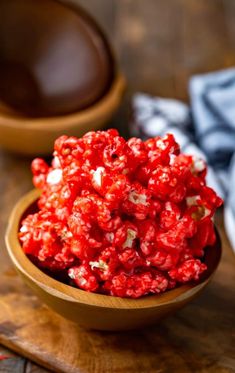 red hot cinnamon popcorn in a wooden bowl on top of a cutting board with text overlay