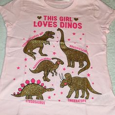 Size M(7/8) "This Girl Loves Dinos" Tyrannosaurus Rex Brachiosaurus Parasaurolophus Stegusaurus Triceratops All In Glittery Gold Reminder App Charges 20% Fee On Items $16 & Over And $3 Fee On Items $15 & Under. All Nwt Items Are Priced At Retail, Reasonable Offers Are Always Welcomed! Pink Dinosaur Print Short Sleeve Top, Pink Dinosaur Print Crew Neck Top, Pink Crew Neck Top With Dinosaur Print, Reminder App, Girl Power Tee, Shark Tee, Girl Empowerment, Live Girls, School Tees