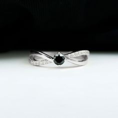 a black and white diamond ring sitting on top of a table