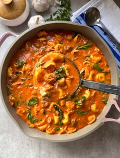 a pot filled with pasta and sauce on top of a table