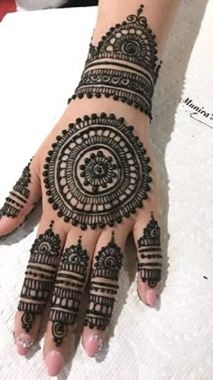 a woman's hand with henna tattoos on it