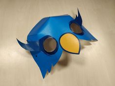 a blue bird mask sitting on top of a wooden table