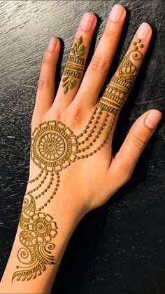 a woman's hand with henna tattoos on it