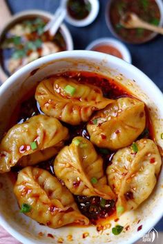 a bowl filled with dumplings covered in sauce