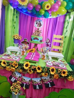 a table set up with sunflowers and decorations for a birthday party or baby shower