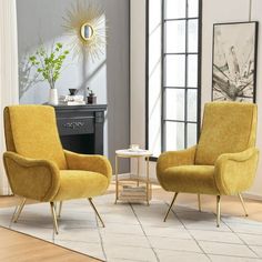 two yellow chairs sitting on top of a wooden floor next to a table and chair