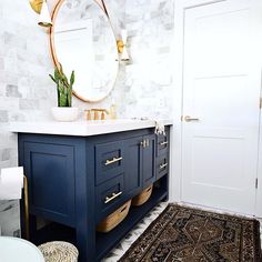 a bathroom vanity with blue cabinets and gold accents