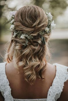 a woman with long hair and flowers in her hair is wearing a flower crown on her head