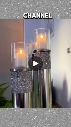 three candles are sitting in glass vases with glitter on the bottom and one candle is lit