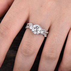 a woman's hand with two engagement rings on it