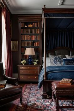 a bedroom with a canopy bed, leather chair and bookshelf