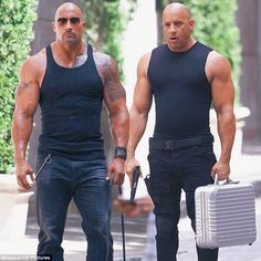 the rock and dwayne wade are walking down the street with their suitcases