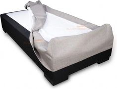 the mattress is covered with a sheet and has been placed on top of it's frame