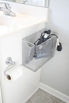 a bathroom with a sink, mirror and toilet paper holder on the wall above it