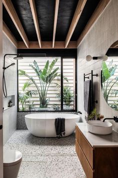 the instagram page shows an image of a bathroom with large windows and plants in it