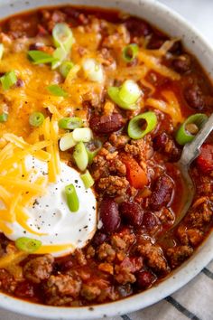 a white bowl filled with chili and cheese