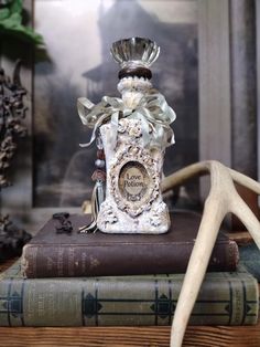 an antler's head is sitting on top of some books and a bottle