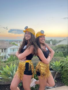 two women dressed in yellow and black posing for the camera with their arms around each other