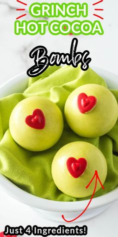 three green apples with red hearts in a white bowl