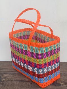 a multicolored basket sitting on top of a wooden table