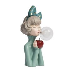 a statue of a girl blowing a bubble with an apple