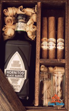 cigars, bottles and other items in an open wooden box with labels on them